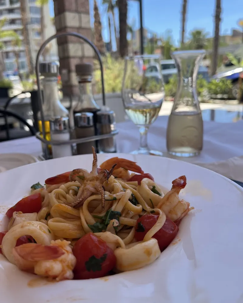 Seafood linguine with prawns, squid and cherry tomatoes on the terrace