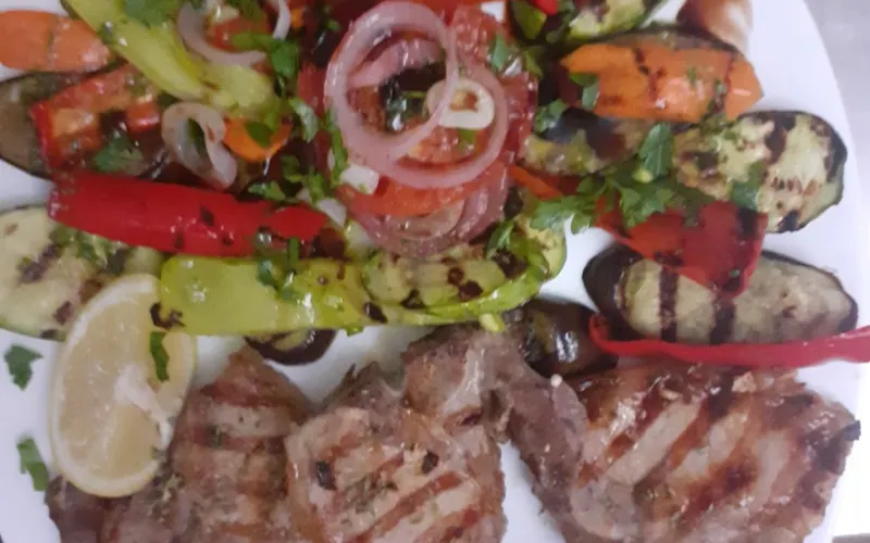 Grilled pork steaks with charred peppers, courgette and onion