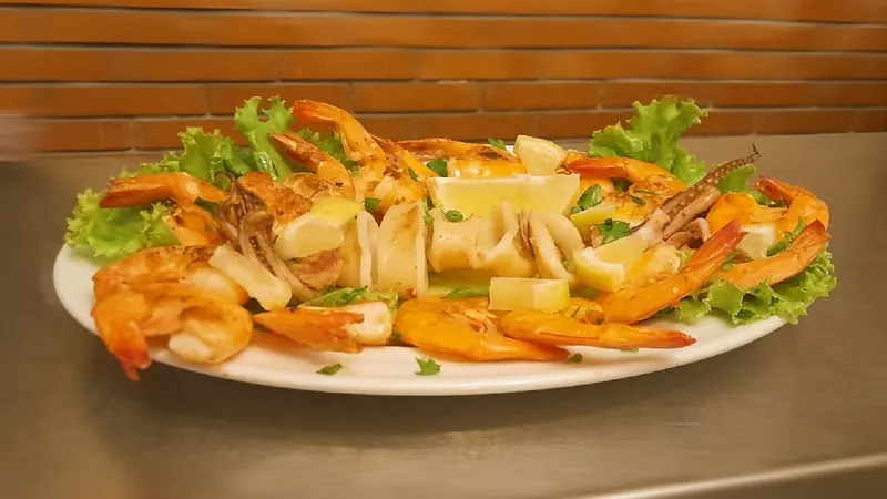 A platter of grilled prawns and squid with lemon and lettuce